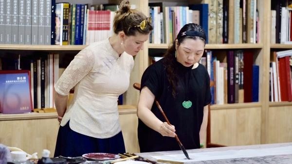 Li Caijiao, member of Chinese Artists Association, shows traditional Chinese painting to Liu Suying on Aug 8..jpg