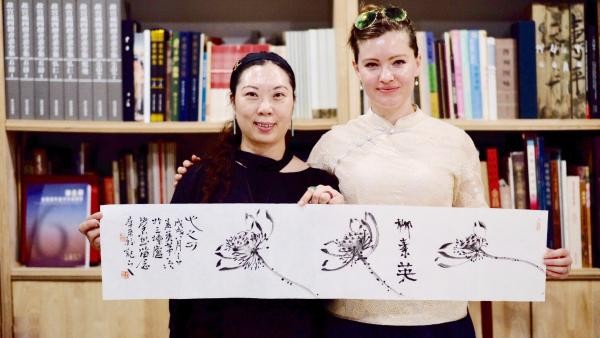 Li Caijiao, a member of the Chinese Artists Association, and Liu Suying present their artistic work depicting lotus flowers on Aug 8..jpg