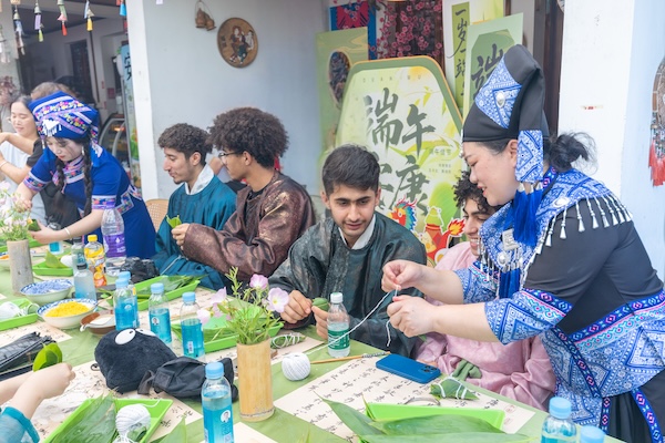 图为壮族姑娘教留学生包粽子，宁波大学供图。(1).jpg
